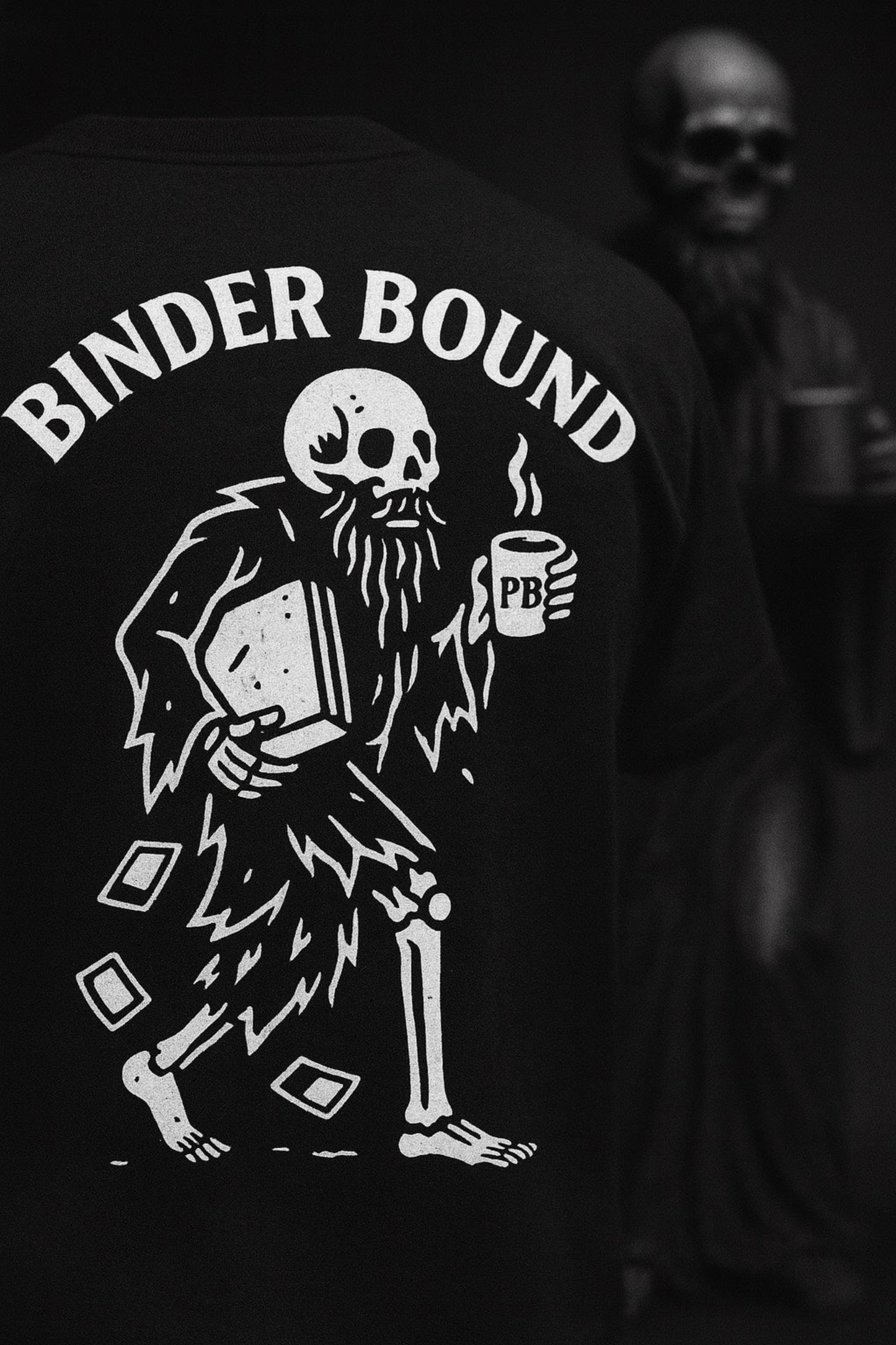 Black t-shirt with skeleton design and 'Binder Bound' text, featuring a skull holding a coffee cup.