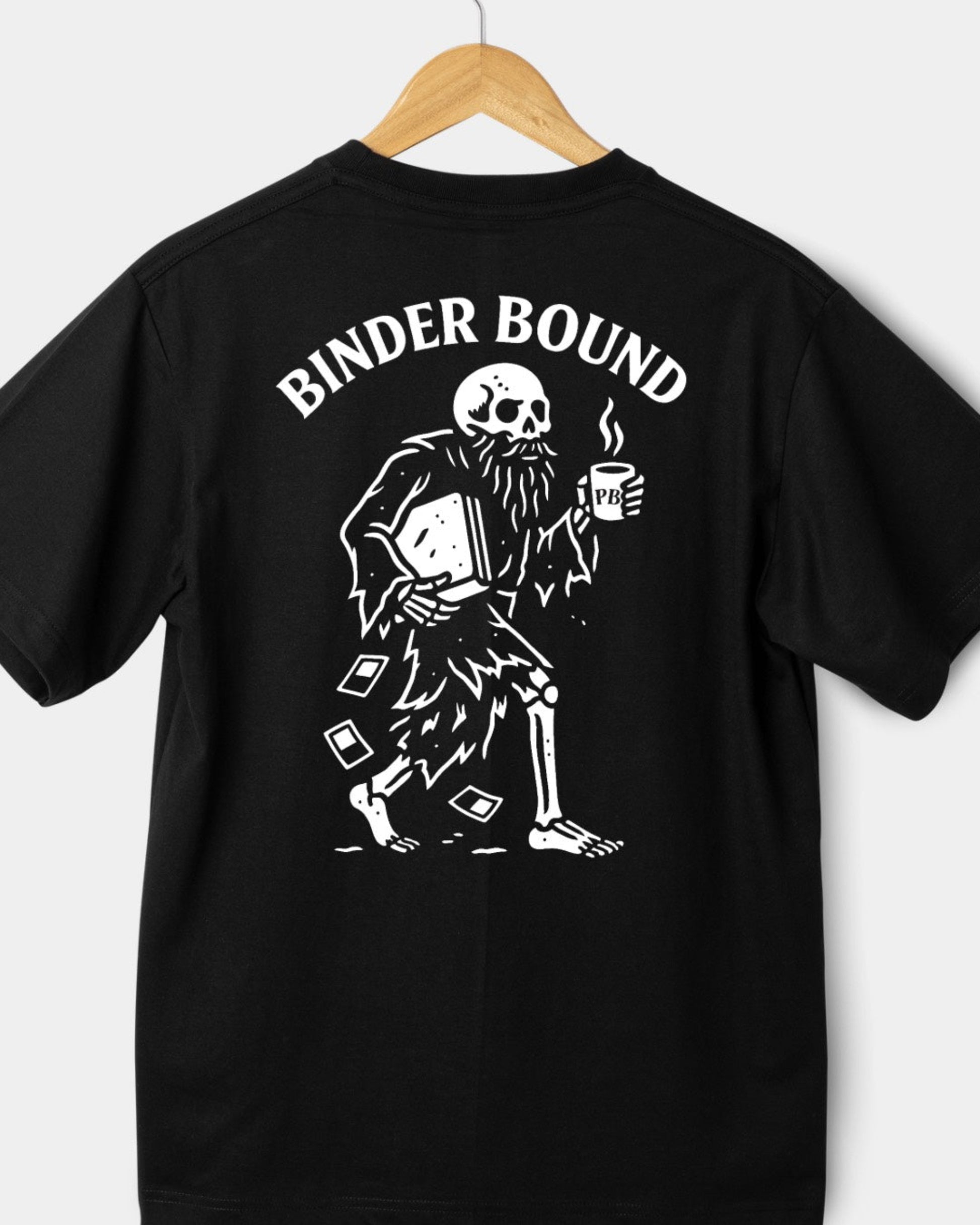 Black t-shirt with a skeleton holding a binder and coffee cup, labeled 'Binder Bound', on a wooden hanger against a white background.
