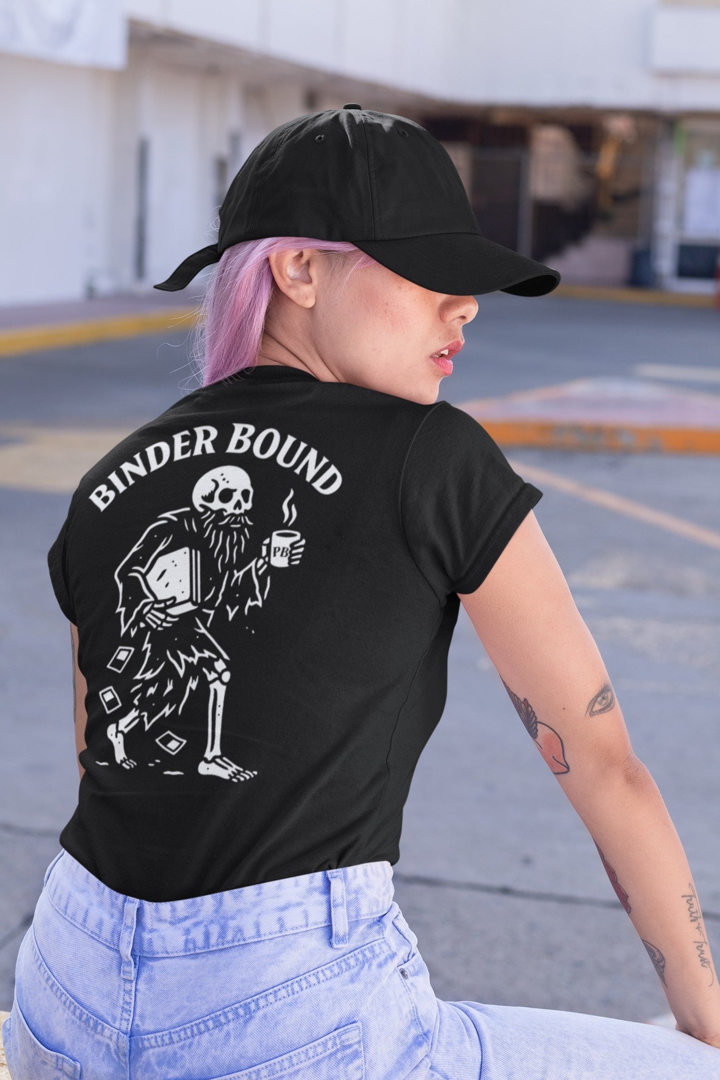Person wearing a black t-shirt with 'Binder Bound' design and text, standing outdoors.